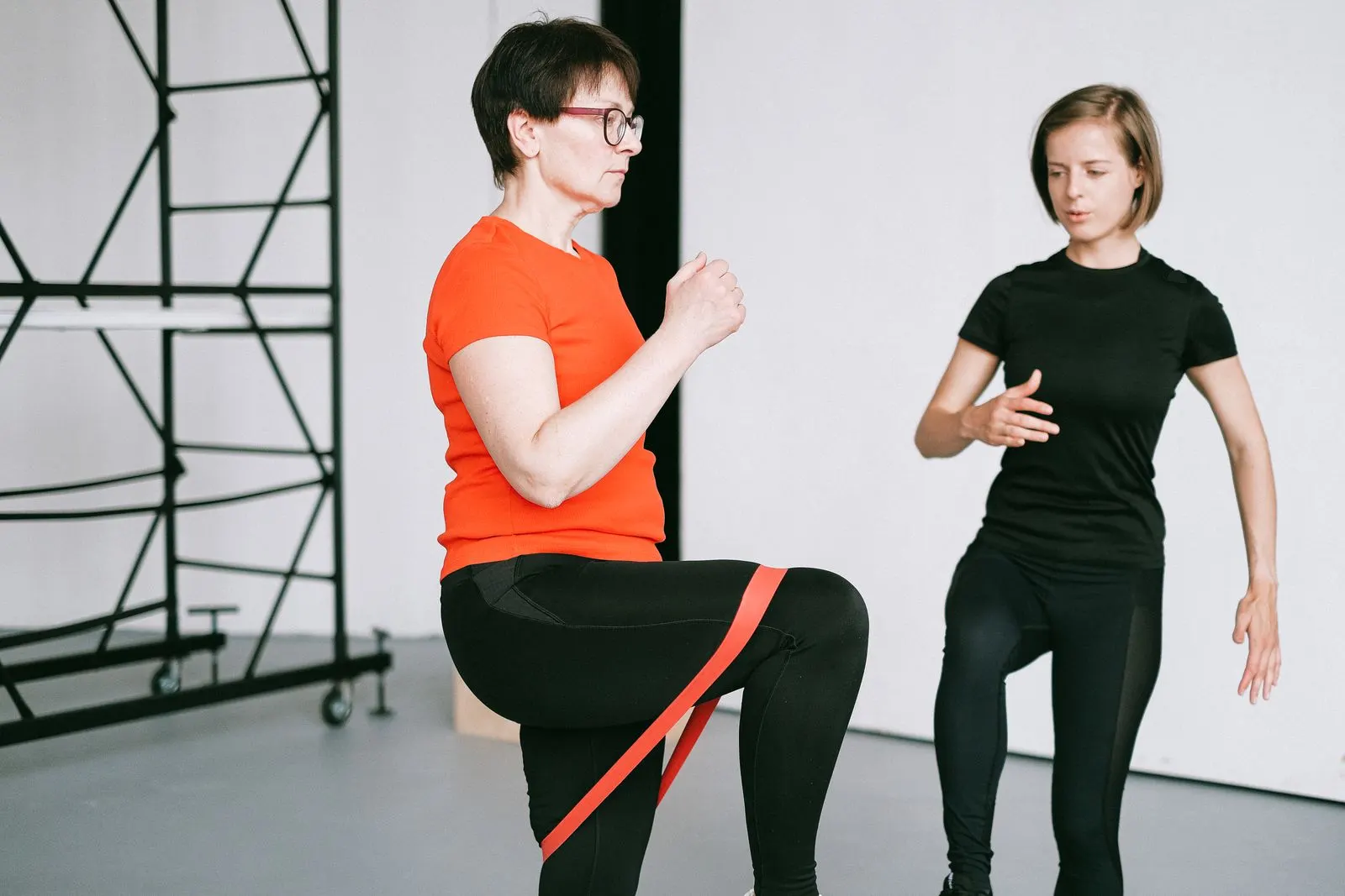 A trainer guiding a client through a resistance band exercise