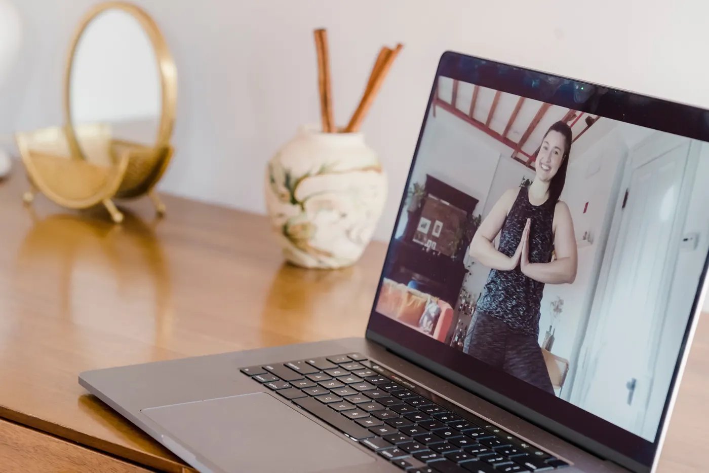 A laptop on a table showing an instructor leading a live workout
